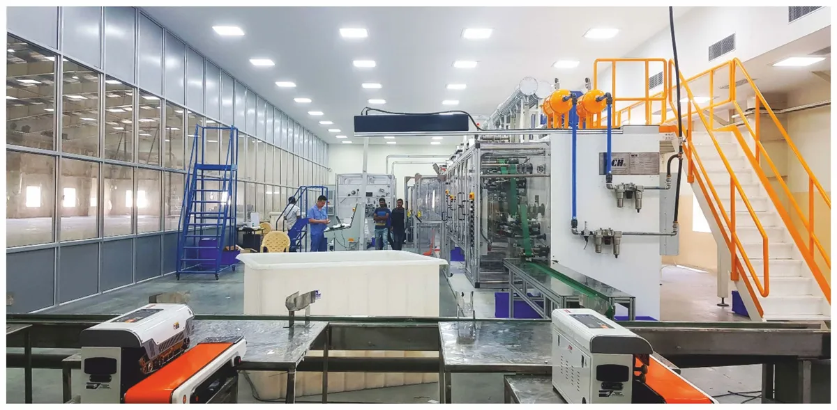 Industrial factory floor with conveyor lines and yellow safety markings inside the Lalita manufacturing unit.